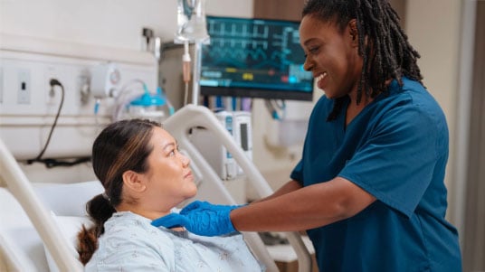 A Registered Dietitian Nutritionist performing a bedside swallow evaluation on a patient. 