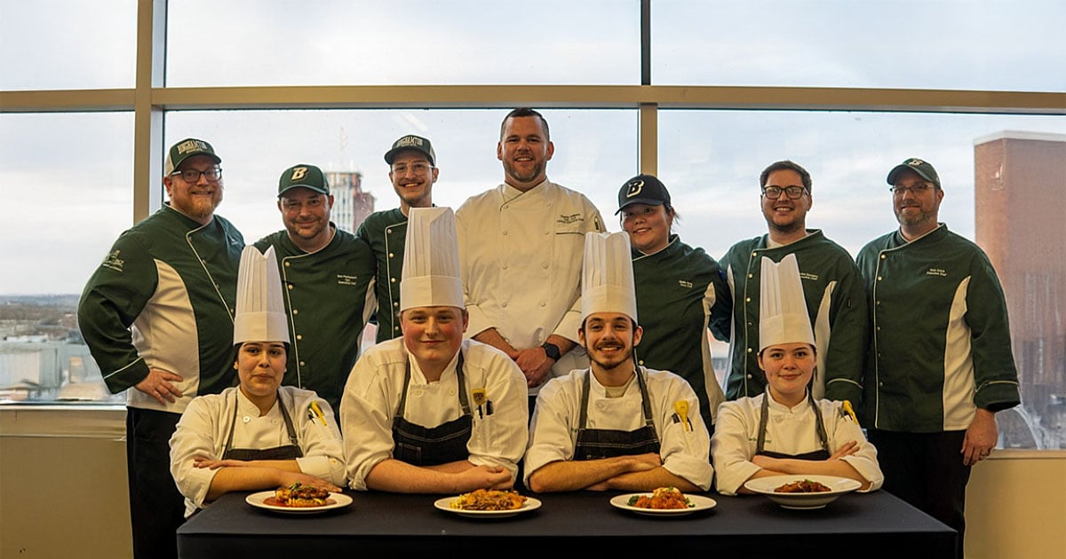 Culinary competitors smiling together with the Binghamton dining team for a group photo.