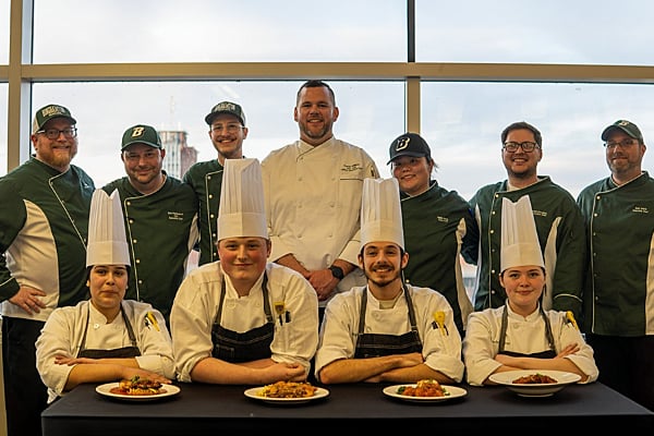 Culinary competitors smiling together with the Binghamton dining team for a group photo.