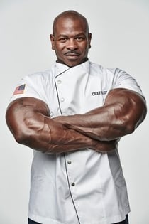 a chef with crossed hands