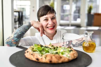 chef woman smiling with pizza