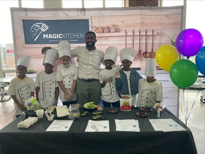 a man with kid chefs smiling