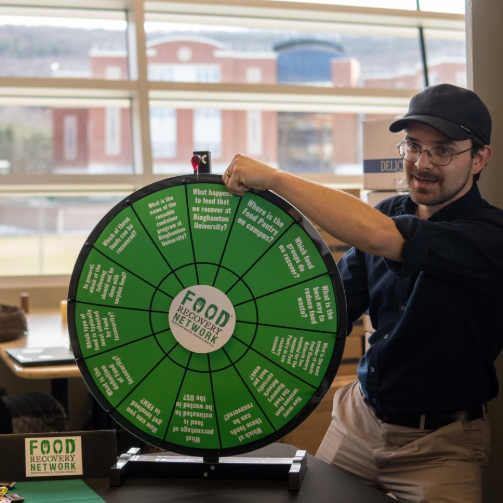 A representative from the Food Recovery Network engaging students with a spin wheel.