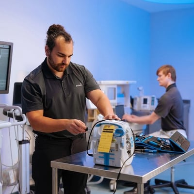 HTM professionals servicing medical equipment, representing the technical expertise that supports modern healthcare technology. 