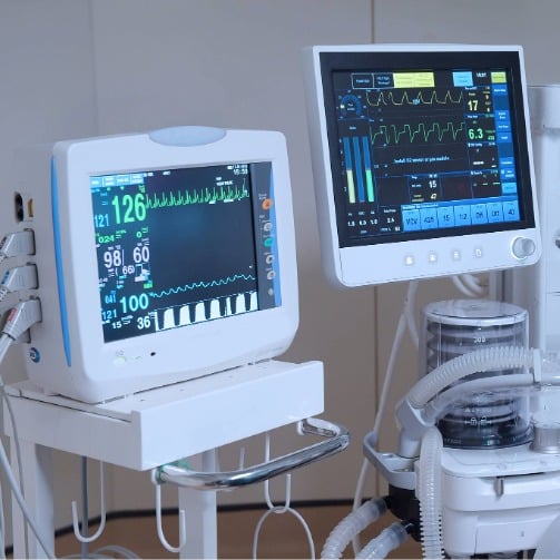 Hospital patient monitors displaying real-time vital signs and respiratory data. 