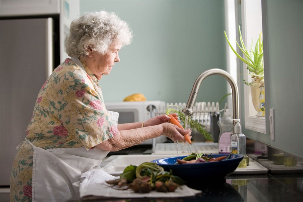 old woman washing fruits