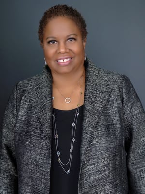 Black woman smiling in gray suit