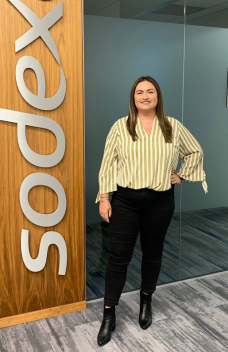woman standing next to Sodexo sign