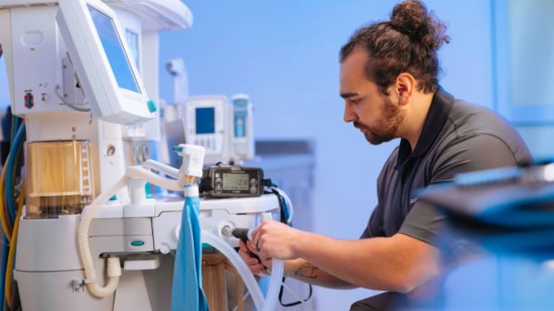 Technician inspecting and servicing medical equipment.
