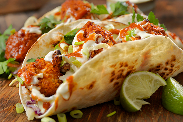 Soft tacos filled with chicken, topped with cilantro, green onion and a squeeze of lime.