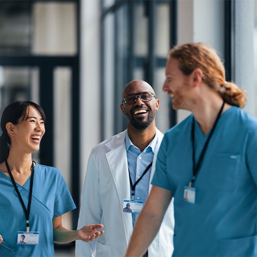 Healthcare professionals walking together through a modern medical facility corridor, highlighting workforce collaboration, care coordination, employee engagement, and connected healthcare support services.