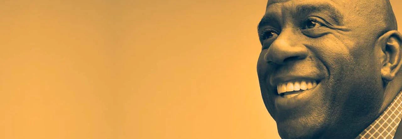 Close-up of a person’s ear and checkered shirt against a solid yellow backdrop.