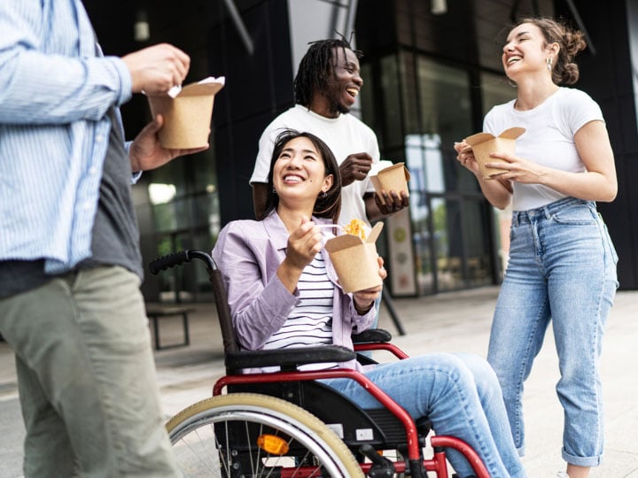 Diverse group of friends enjoying takeout lunch outdoors