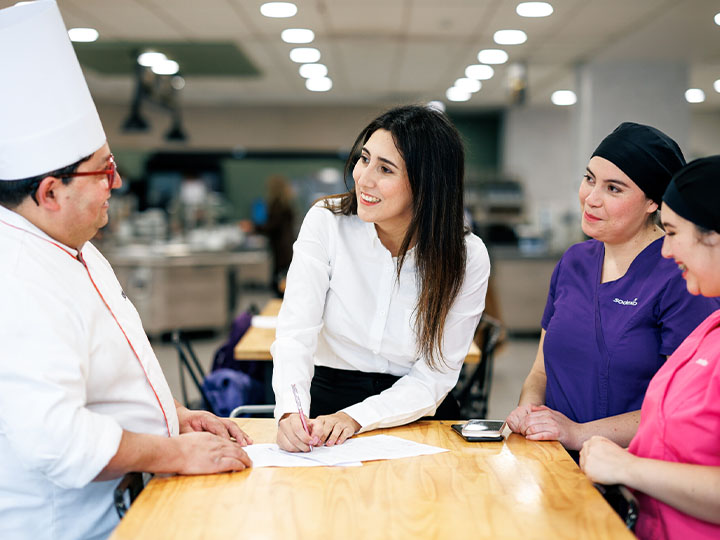women talking to a chef