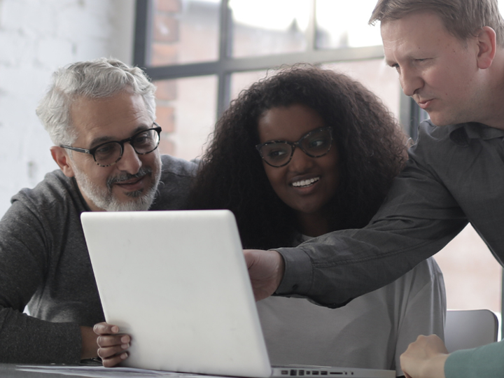 people looking a laptop and smiling