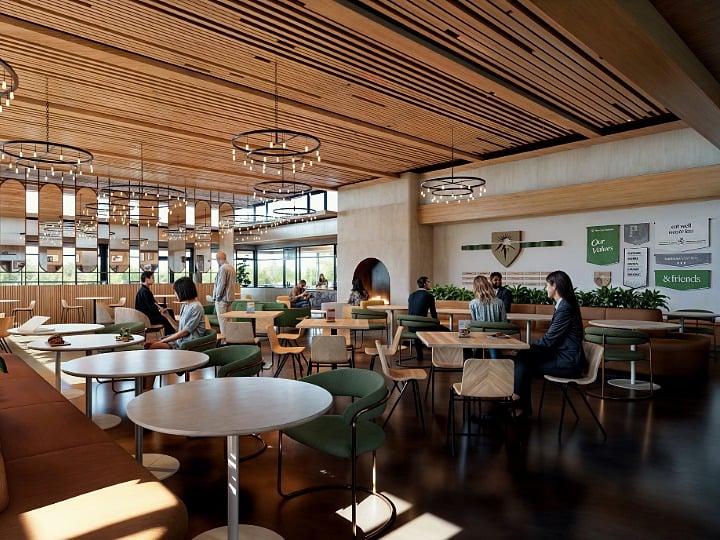 Modern dining hall with wood accents, chandeliers, and warm-toned tables and chairs, with people gathered around.