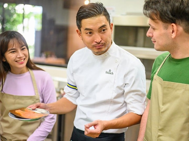 A chef interacting with students as they participate in a hands-on cooking class.