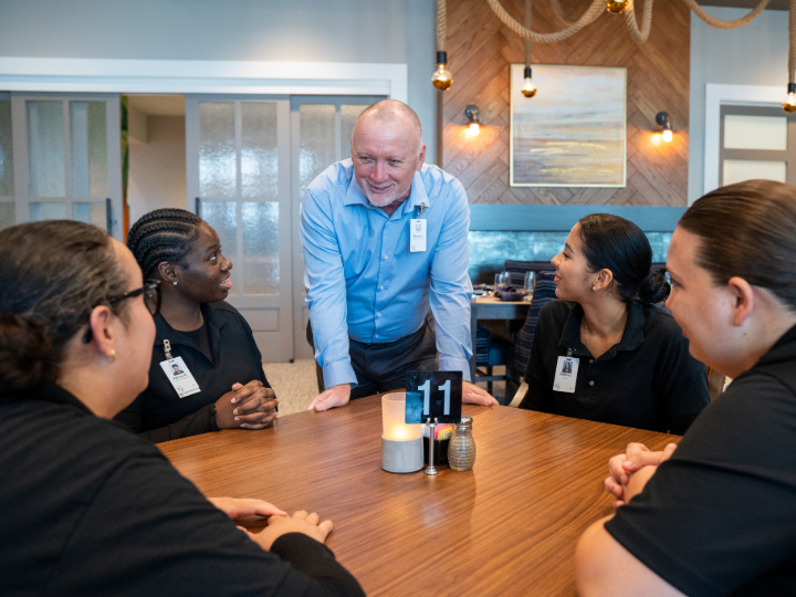 Manager speaking to employees during a team huddle.