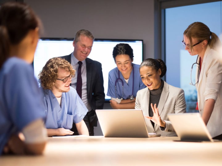 Hospital team sitting together in a room for a business review. 