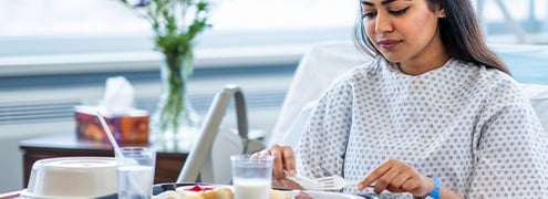 A young female patient eating a well balanced meal in a hospital setting
