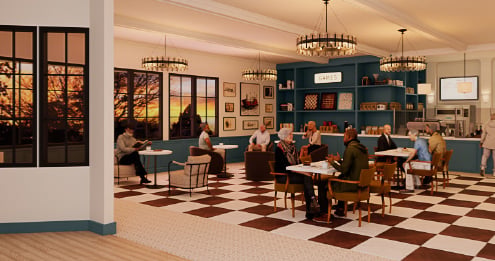 Residents and visitors gathered in a comfortable community café and lounge area, seated at tables and conversation spaces designed to support social interaction, dining, and wellness-focused living.