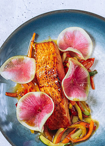 salmon with vegetables on a blue plate