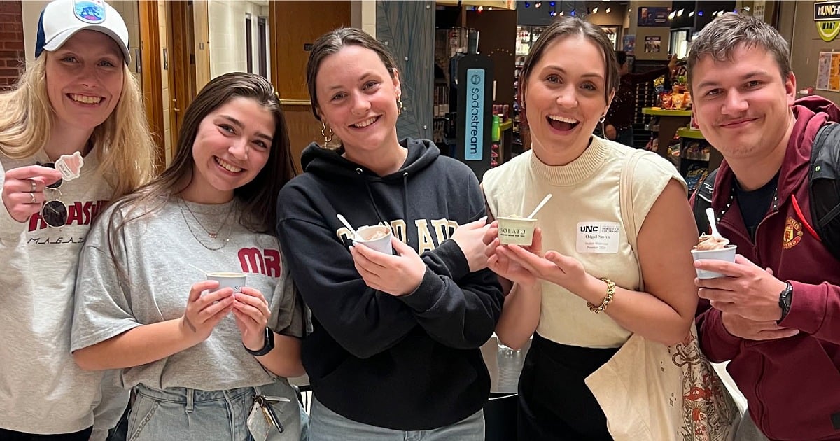 A group of UNC students smile for a photo, each holding a cup of Solato ice cream. 
