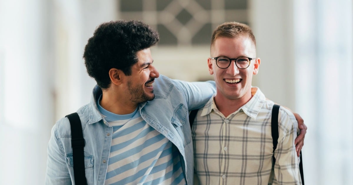Two college students sharing a laugh while walking on campus.