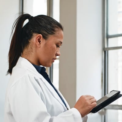 A clinician using a tablet to review patient information. 