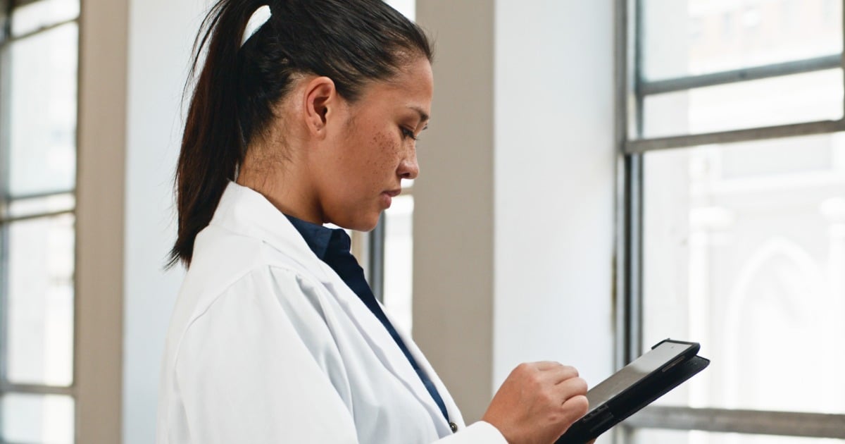 A clinician using a tablet to review patient information. 