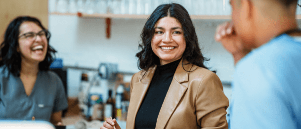 People talking together in a café-style setting near a counter.