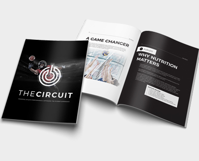 Printed report and open booklet displayed on a light background, featuring athletic performance content with articles and graphics.