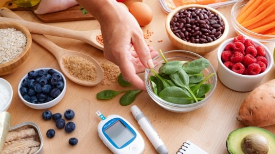 Assortment of diabetes-friendly foods such as leafy vegetables, fresh berries and whole grains