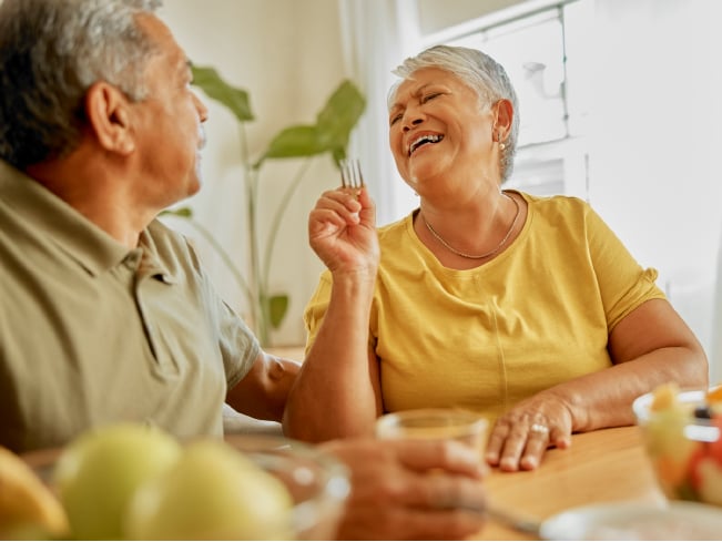 Two adults seated at a dining table sharing conversation during a meal, highlighting social engagement, meaningful connections, hospitality, and wellness-focused dining experiences.