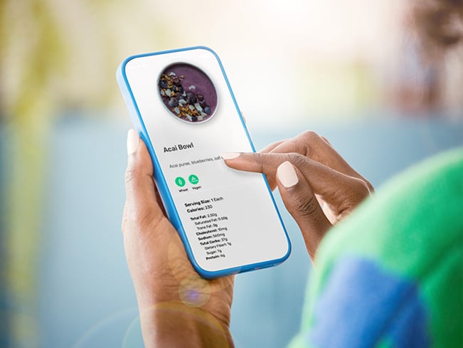 Person using a mobile app to view nutrition information and menu details for an acai bowl