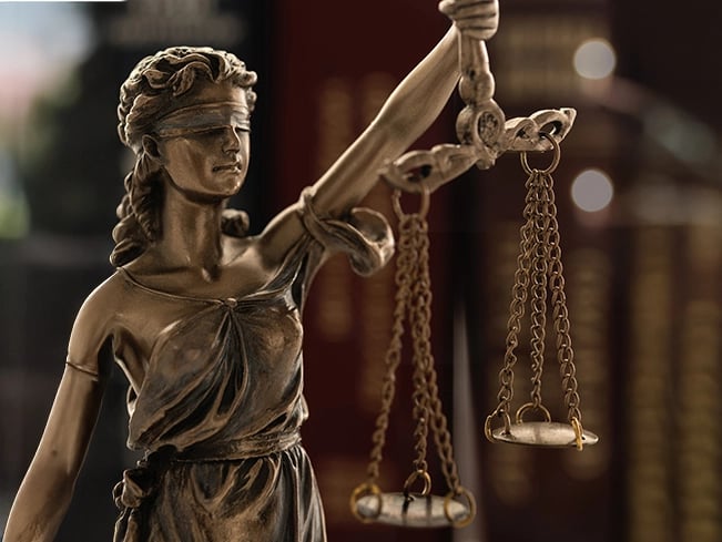 Bronze Lady Justice statue holding law scales.