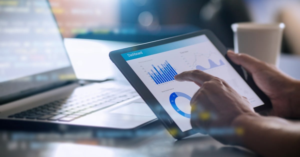 Close up of a HTM professional using a tablet displaying a real-time analytics dashboard. 
