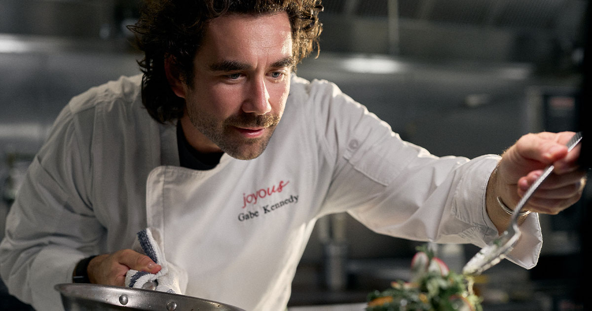Professional chef plating a fresh meal in a commercial kitchen, highlighting culinary expertise, food preparation, menu innovation, and high-quality dining experiences.