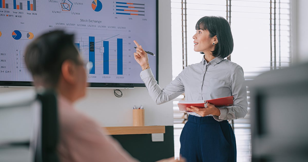 Professional presenting business performance charts and data insights on a large screen during a meeting, highlighting sales strategy, analytics, decision-making, and organizational planning. Proporcione sus comentarios sobre BizChat