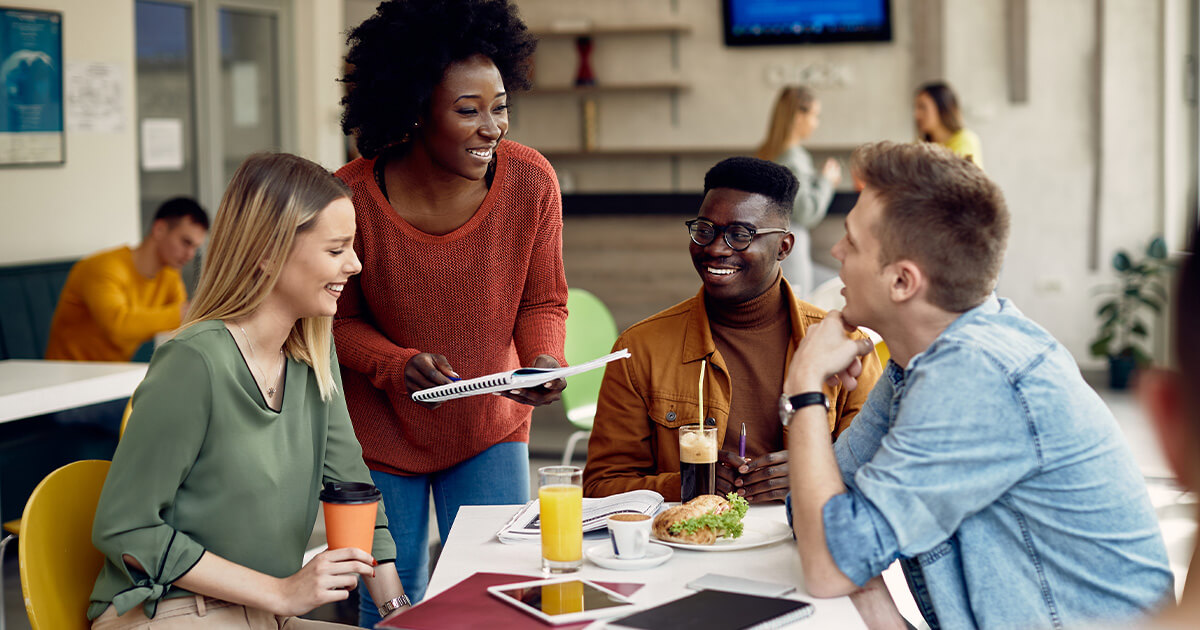 People discussing documents together around a table in a bright collaborative workspace.