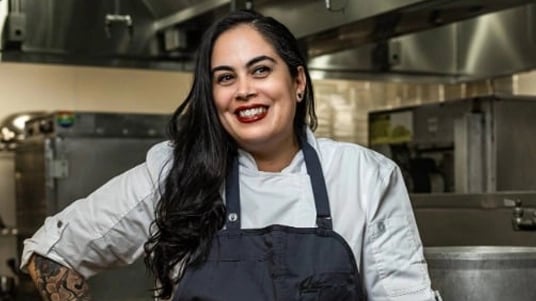 Chef Melody Miranda smiling in a kitchen