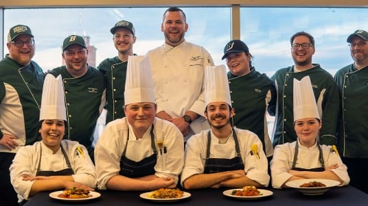 Culinary competitors smiling together with the Binghamton dining team.