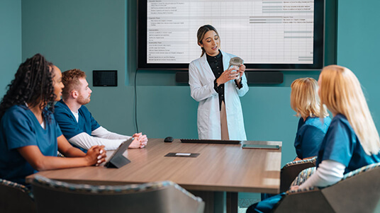 Healthcare team members collaborating during a nutrition and patient care planning meeting.
