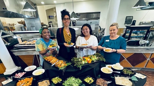 Eastern New Mexico University students posing with their custom bowl creations at a campus wellness event.