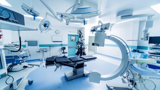 A brightly lit operating room equipped with various equipment.