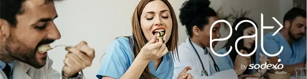 Group of people, likely healthcare professionals, sitting together and eating.