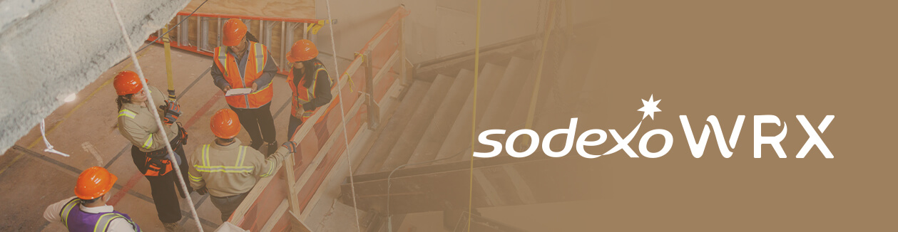Construction workers in hard hats meet at indoor worksite, with Sodexo WRX logo on the right