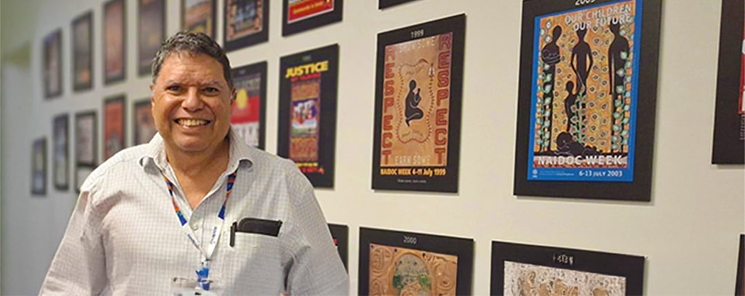 wayne-davis-standing-in-front-of-indigenous-artwork-wall
