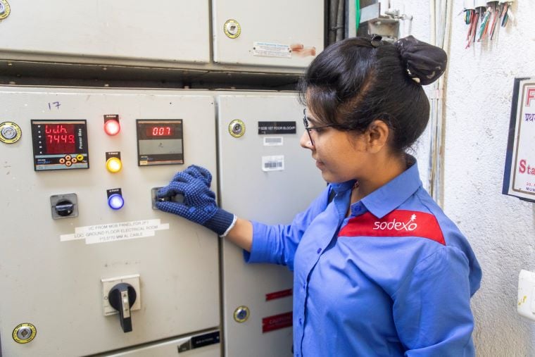 Sodexo worker inspects the control panel with care