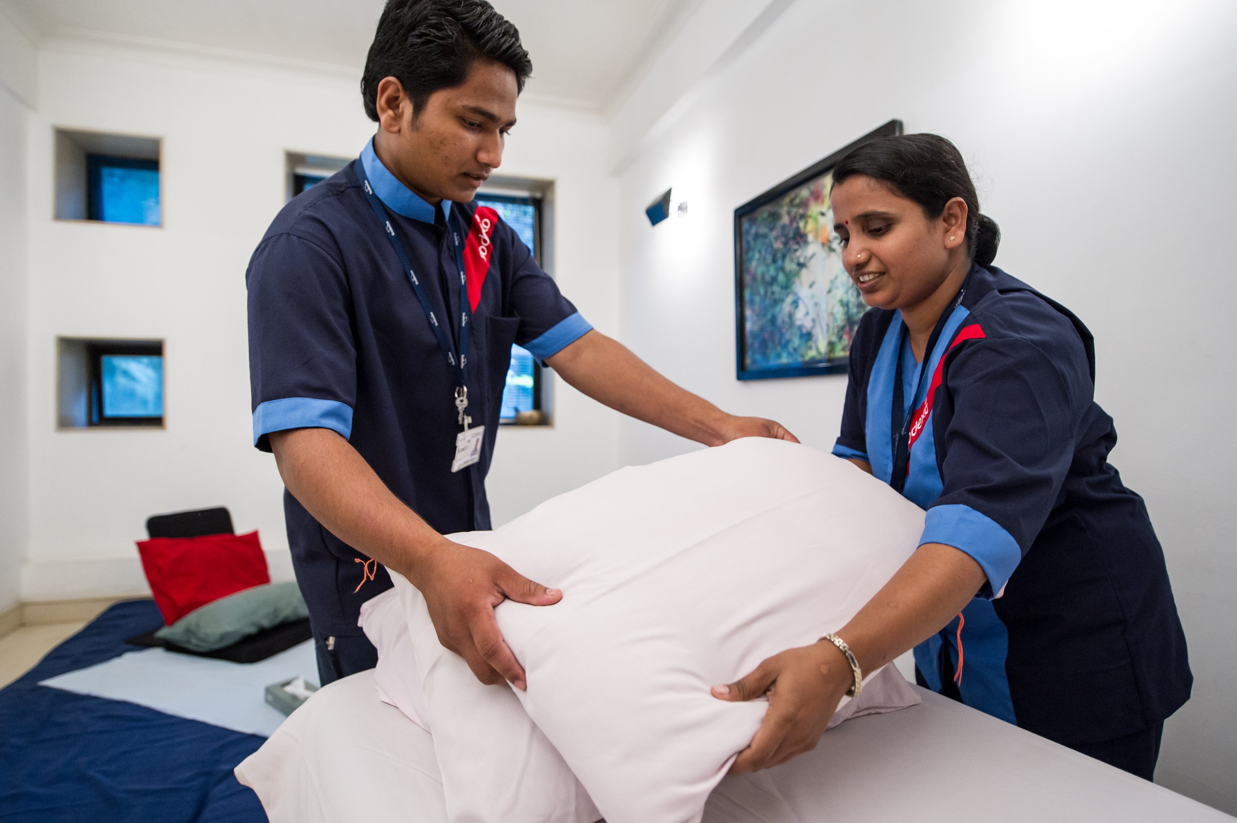 Two Sodexo workers assemble pillows in hostel